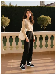 Full view of women's lightweight casual sneakers styled with black wide-leg trousers outdoors