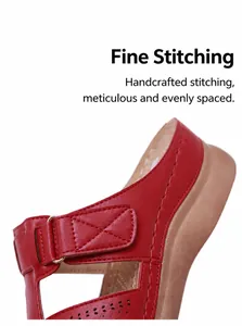 Détail de sandales rouges avec coutures de précision, motifs laser et boucle en métal