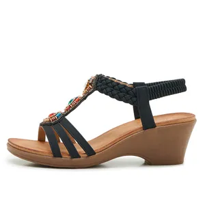 Détail de sandales compensées bohèmes avec perles colorées et paillettes sur bride en T