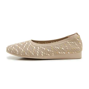Side view of beige knitted ballet flats showing textured wave pattern and flexible soles