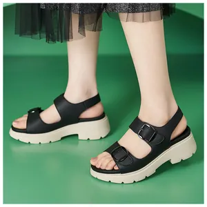 Dettaglio di sandali neri con zeppa dotati di fibbie metalliche e suola platform alta