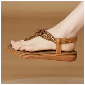 Detail of bohemian T-strap sandals with floral rhinestone beads and elastic heel strap