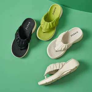 Nahaufnahme modischer Plateau-Flip-Flops mit gerafften Riemen und rutschfester Sohle in drei Farben