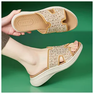 Close-up van beige sleehak sandalen met strass H-vormige bandjes en comfortabele zool