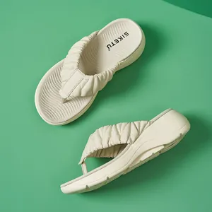 Detailansicht der cremefarbenen Plateau-Flip-Flops mit gerafften Riemen und Wellenmuster