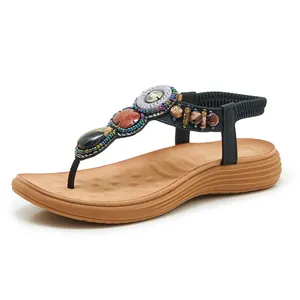 Detail of bohemian wedge sandals featuring ethnic beads and patterned silver rings