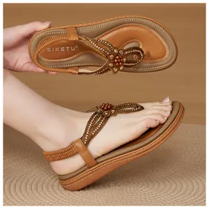 Detail of bohemian T-strap flat sandals with rhinestone flower beads and elastic heel strap