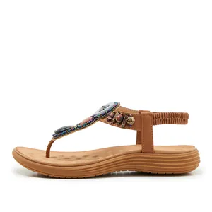 Detail of bohemian T-strap flat sandals with colorful wooden beads and crystal stones