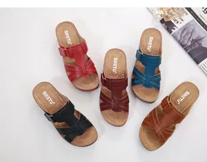 Vue à plat de sandales compensées pour femmes en cinq couleurs avec motifs ajourés et boucles