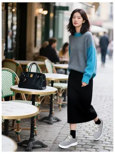 Outdoor street style view of grey platform sneakers with black skirt and knit sweater