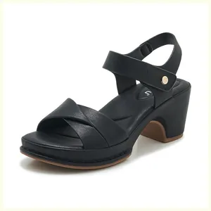 Close-up of women's black leather sandals featuring cross straps and chunky block heels