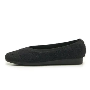 Close-up of black knitted plush flat shoes for women with soft woven texture details