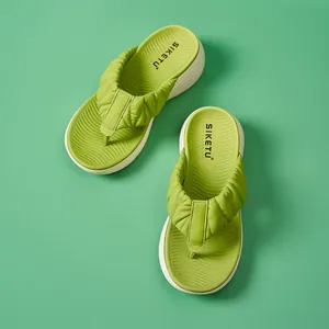 Draufsicht auf grüne Plateau-Flip-Flops mit gerafften Riemen und strukturierter Sohle