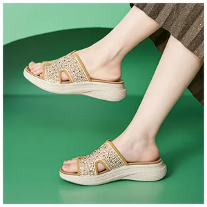 Zijaanzicht van stijlvolle beige platform sandalen met glinsterende strassteentjes aan voet