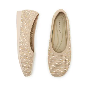 Close-up of beige woven flat shoes showing intricate knit texture and round toe design