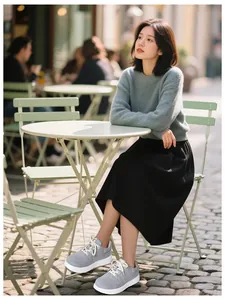 Outdoor lifestyle shot of grey chunky platform lace-up sneakers for women in a cafe
