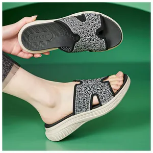 Detailopname van zwarte damesplatform sandalen met glanzende strass-steentjes op de band