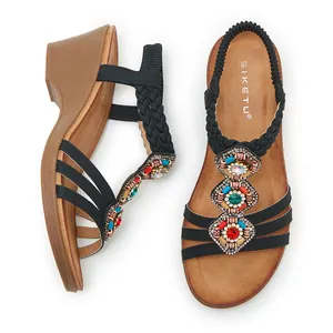 Détail de sandales compensées bohèmes avec perles multicolores et strass brillants