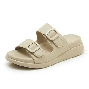 Gros plan de sandales à plateforme beige avec doubles brides bouclées et semelle confort