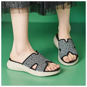 Macro-opname van sprankelende platform sandalen met H-band en strassteentjes op groen