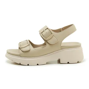 Dettaglio di sandali con zeppa beige con fibbie in metallo e suola antiscivolo spessa