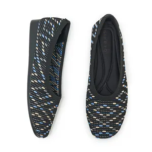 Macro detail of black knit flat shoes featuring colorful oval geometric patterns and soft sole