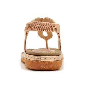 Detail view of champagne gold wedge sandals featuring elastic back straps and non-slip soles