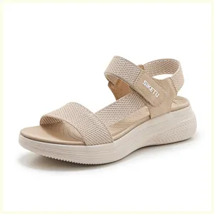 Gros plan de sandales compensées beige en maille respirante avec bride velcro cheville