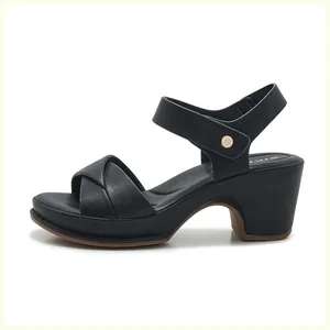 Detail of black block heel sandal with gold S-logo buckle and secure ankle strap