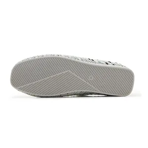 Detail view of anti-slip rubber sole with texture on grey woven flat shoes size 36