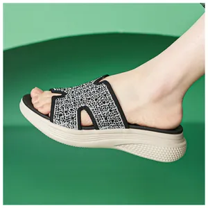 Detail van zwarte strass en beige plateauzool op zomerse damessandalen met sleehak