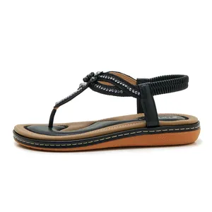 Detail of bohemian flat sandals with sparkling rhinestones and elastic heel strap