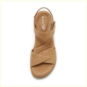 Top-down view of tan leather sandals featuring crossover straps and decorative stitching detail
