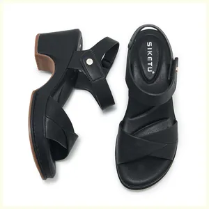 Close-up of black wedge sandals with crossover straps and soft ergonomic footbed