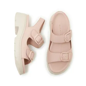 Dettaglio di sandali con zeppa rosa chiaro con fibbie in metallo e cinturini in ecopelle