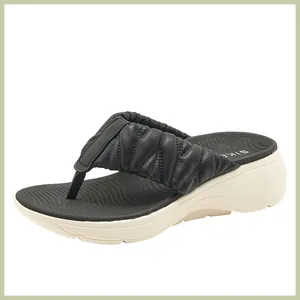 Detailansicht der Plateauschuhe mit eleganten, gerafften Lederriemen in Schwarz-Beige