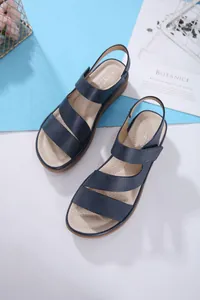 Dettaglio dei cinturini in pelle blu navy e del plantare imbottito di questi sandali donna