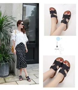 Détail des sandales à plateforme noires avec brides croisées et boucle pour femme