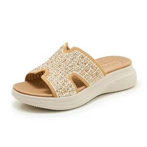 Detail van beige gebreide slippers met plateauzool, strass-steentjes en uitsnijdingen