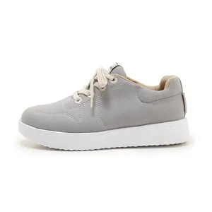 Detail of grey low-top canvas sneakers with white stitching and chunky non-slip sole