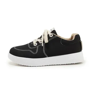 Close-up of black canvas sneaker featuring white contrast stitching and thick rubber sole