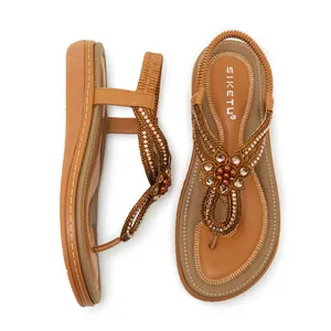 Detail of bohemian flat sandals with rhinestone flower pattern and elastic back strap