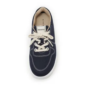 Top view of blue canvas sneakers with white contrast stitching and durable rubber soles