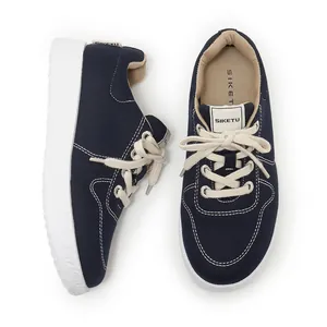 Detailed top and side view of navy blue canvas sneakers with thick white soles