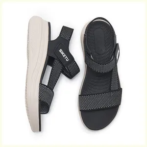 Détail de sandales SIKETU à plateforme en tissu noir avec des pois blancs