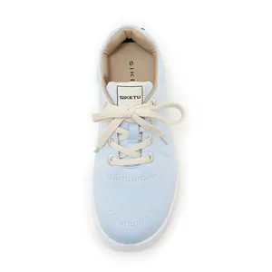 Detailed top view of light blue canvas sneakers with white laces and brand logo