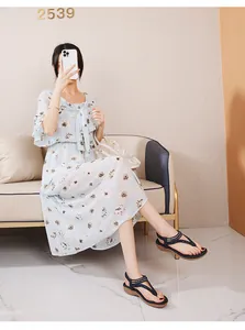 Damen-Sommeroutfit mit hellblauem Blumenkleid und perlenbesetzten Keilsandaletten