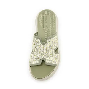 Detail van gebreide damessandaal met gouden strass-steentjes en zacht groen comfortabel voetbed