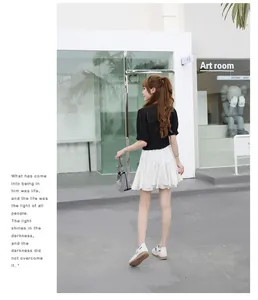 Detail of wedge platform sandals styled with a white pleated mini skirt and black blouse