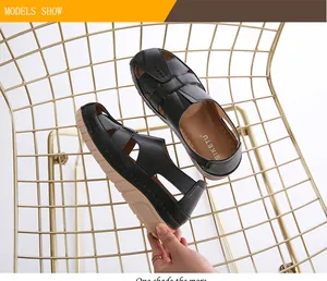 Detail view of black faux leather cutout sandals with wedge sole and brand logo